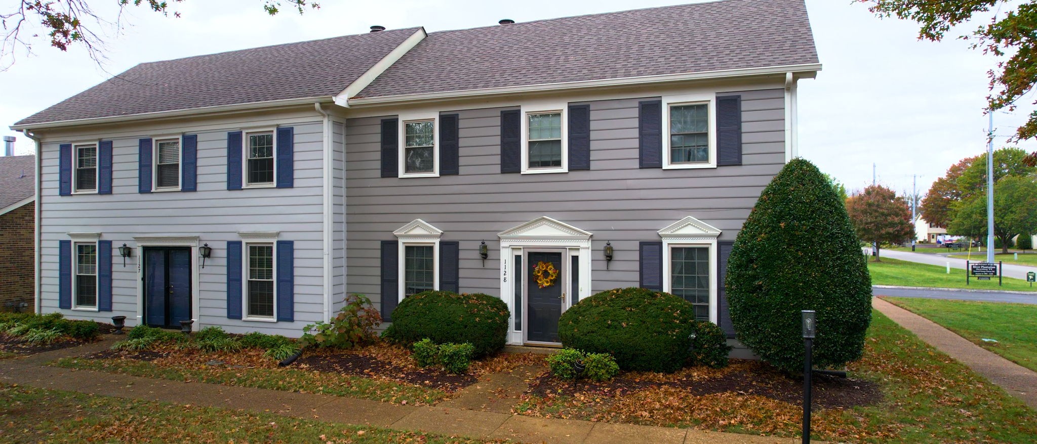 a front view of a house with garden and plants