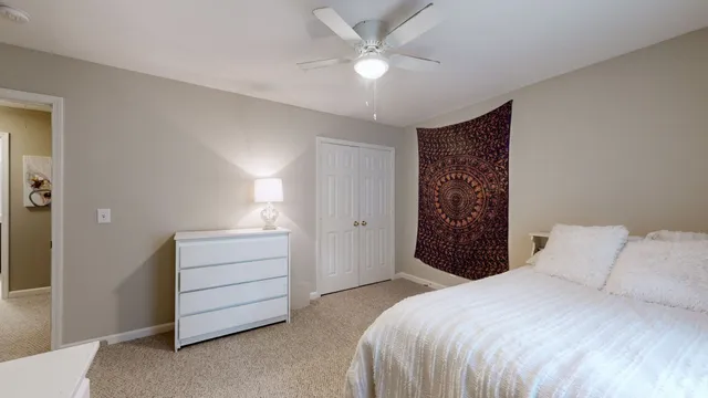 a bedroom with a bed and a ceiling fan