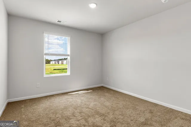 an empty room with a window and tub