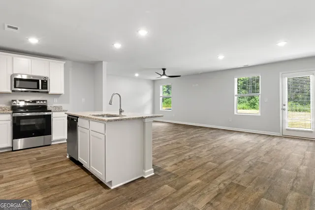 a kitchen with granite countertop a stove top oven and a sink