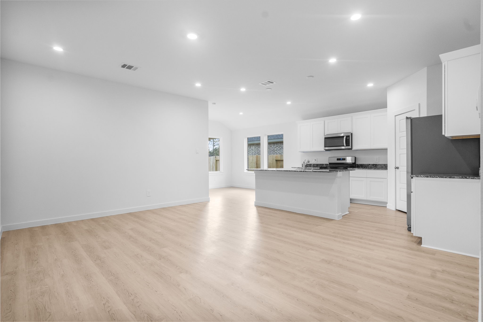 11 Robin Court Angleton, TX 77515 - Photo 6 of 21 a view of kitchen with kitchen island granite countertop a stove top oven a sink and a refrigerator
