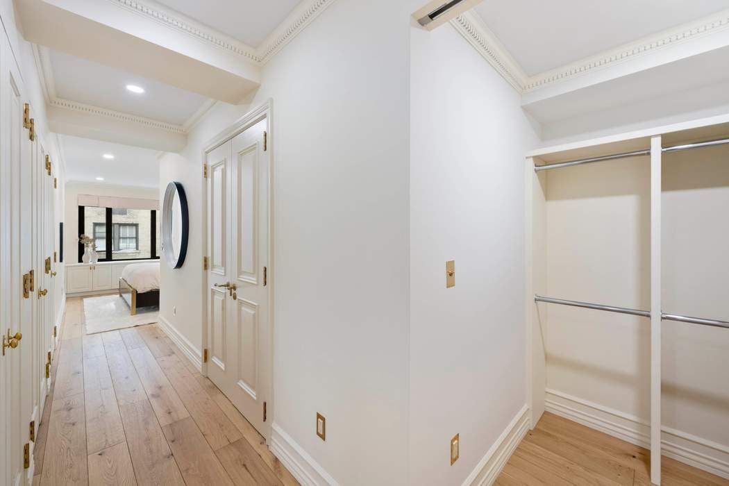 47 East 87th Street, Unit 7A Manhattan, NY 10128 - Photo 6 of 14 a view of a hallway with wooden floor and staircase