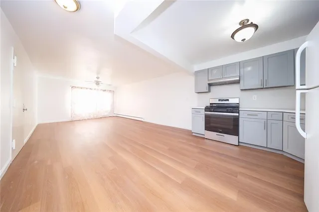 a view of a kitchen with wooden floor and electronic appliances