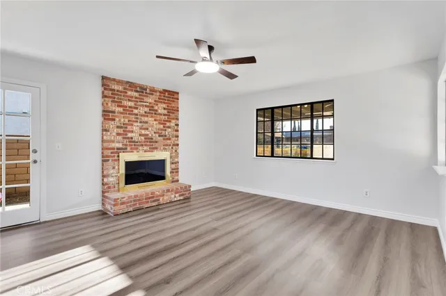 a kitchen with stainless steel appliances a stove top oven a sink a refrigerator white cabinets and wooden floor