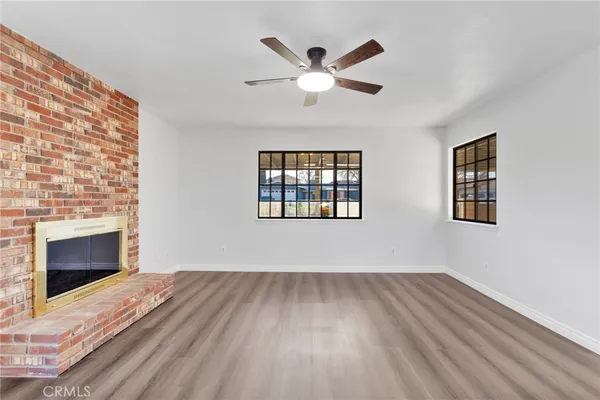 a kitchen with stainless steel appliances a stove top oven a sink a refrigerator white cabinets and wooden floor