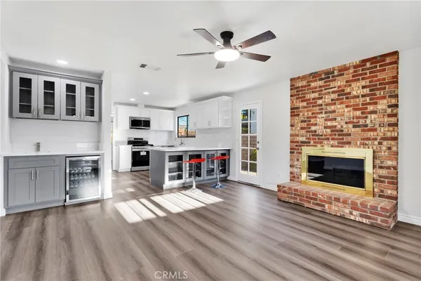 a kitchen with stainless steel appliances white cabinets a sink a stove a microwave and wooden floors