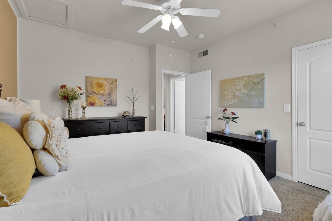 11203 Ranch Road 2222, Unit 2305 Austin, TX 78730 - Photo 20 of 36 a bedroom with a bed and ceiling fan