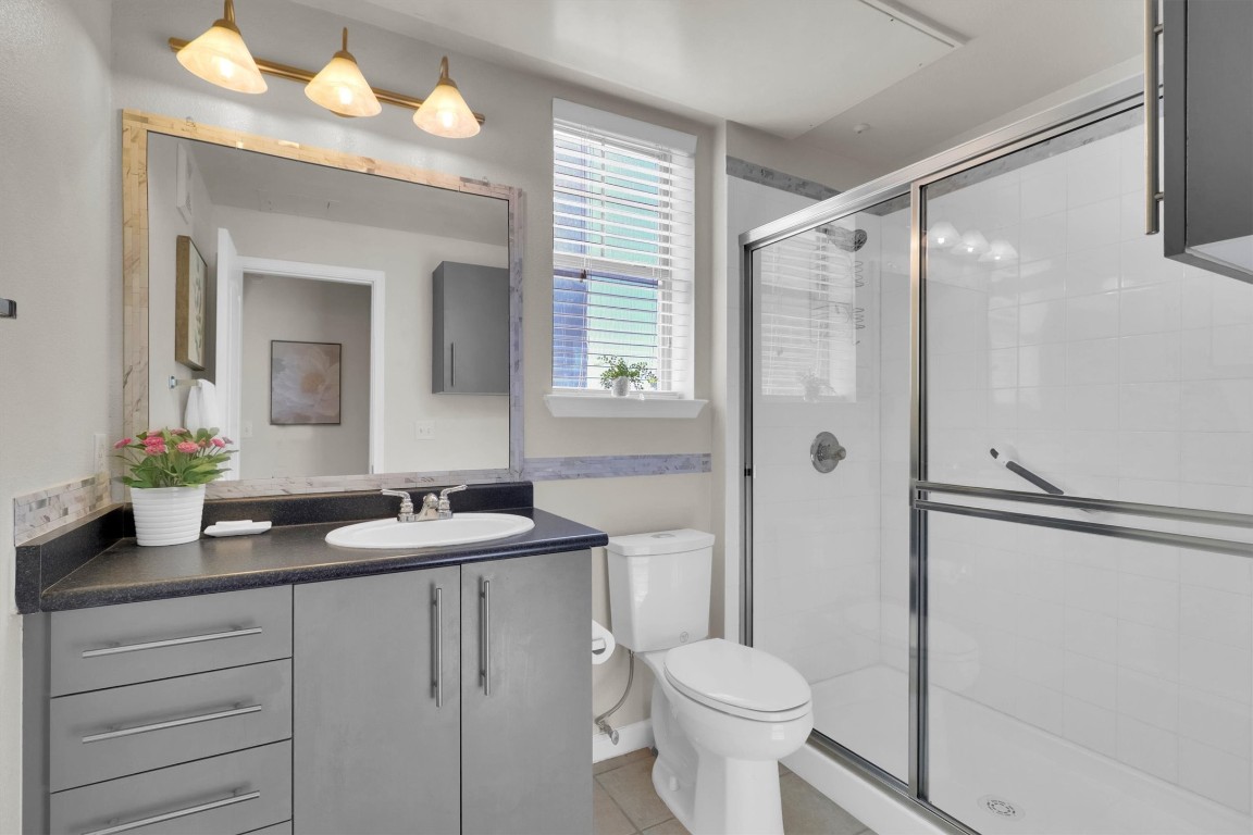 11203 Ranch Road 2222, Unit 2305 Austin, TX 78730 - Photo 21 of 36 a bathroom with a double vanity sink mirror and toilet