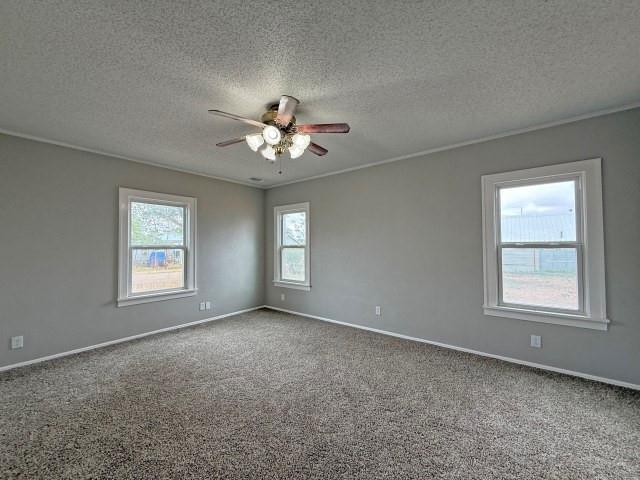 1001 North 3rd Street Lamesa, TX 79331 - Photo 25 of 32 an empty room with chandelier fan and windows