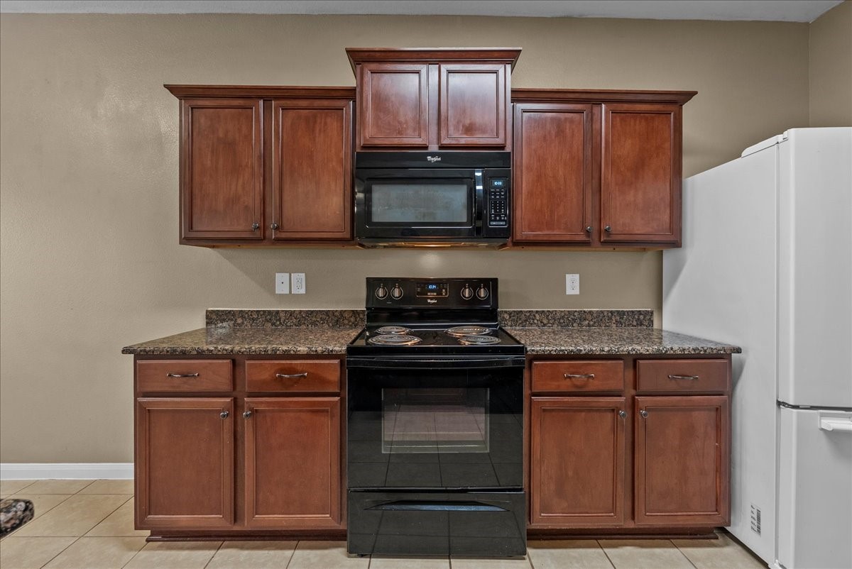 322 Shoshone Ridge Drive La Marque, TX 77568 - Photo 13 of 34 a kitchen with granite countertop wood cabinets and stainless steel appliances