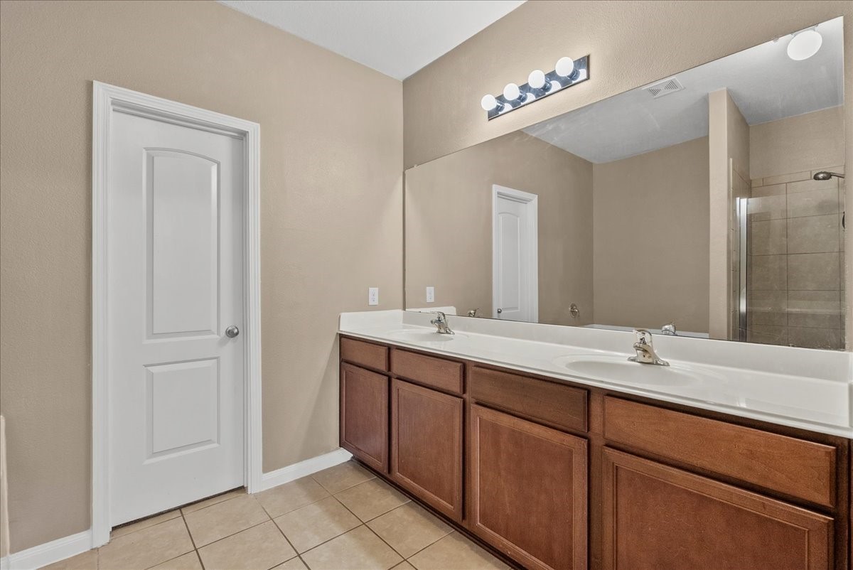 322 Shoshone Ridge Drive La Marque, TX 77568 - Photo 19 of 34 a bathroom with a double vanity sink and a mirror