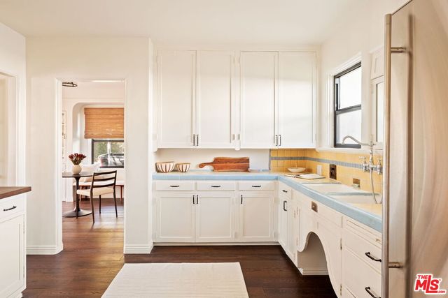 a kitchen with a sink cabinets and wooden floor