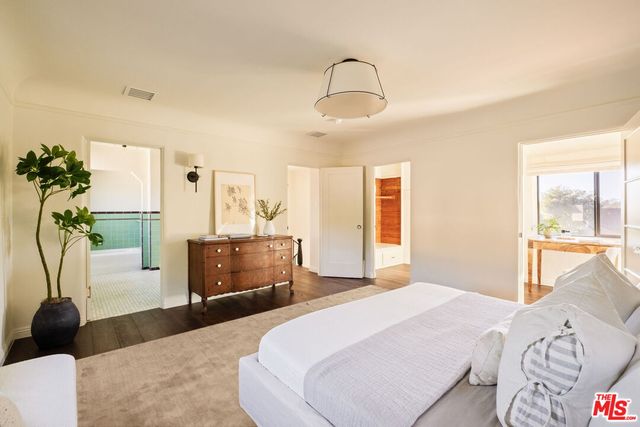 a spacious bedroom with a bed a couch and dresser