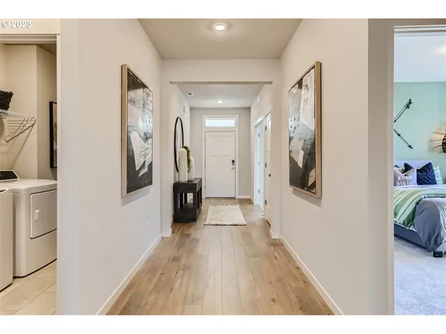 a hallway with a wooden floor and a bathroom