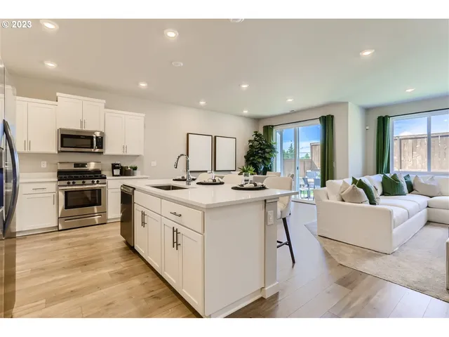 a kitchen with stainless steel appliances kitchen island granite countertop a stove and a sink