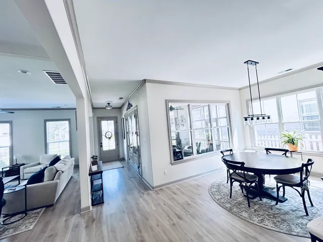 a view of a a dining room with furniture window and wooden floor
