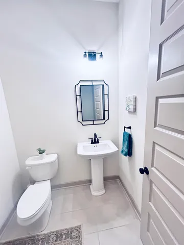 a bathroom with a toilet a sink and mirror