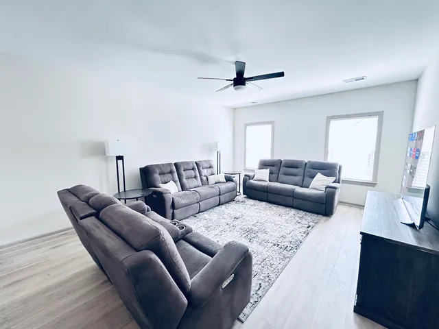 a living room with furniture and a ceiling fan
