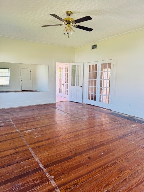 217 Main Street Palacios, TX 77465 - Photo 8 of 45 an empty room with wooden floor fan and windows