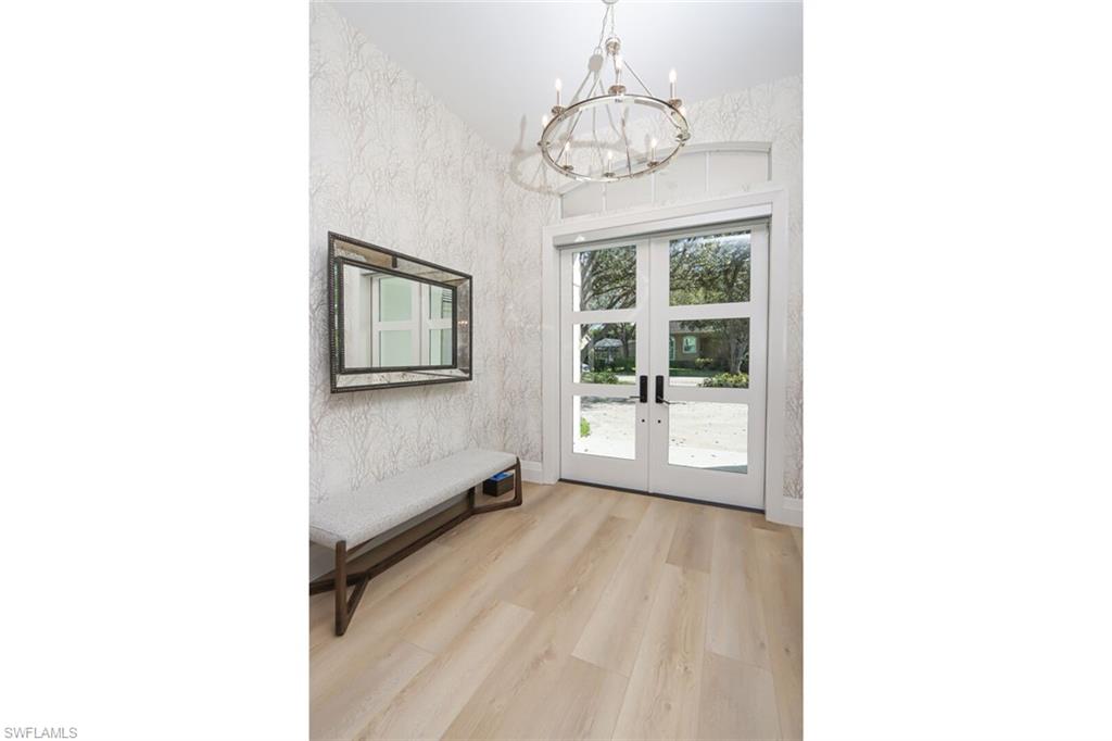 6665 Mill Run Road Naples, FL 34109 - Photo 12 of 30 a view of a room with a large window and couches