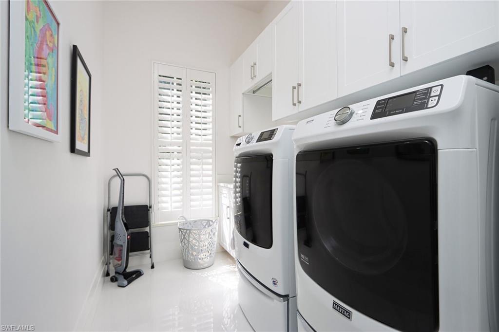 6665 Mill Run Road Naples, FL 34109 - Photo 13 of 30 a view of washer and dryer with kitchen in the background