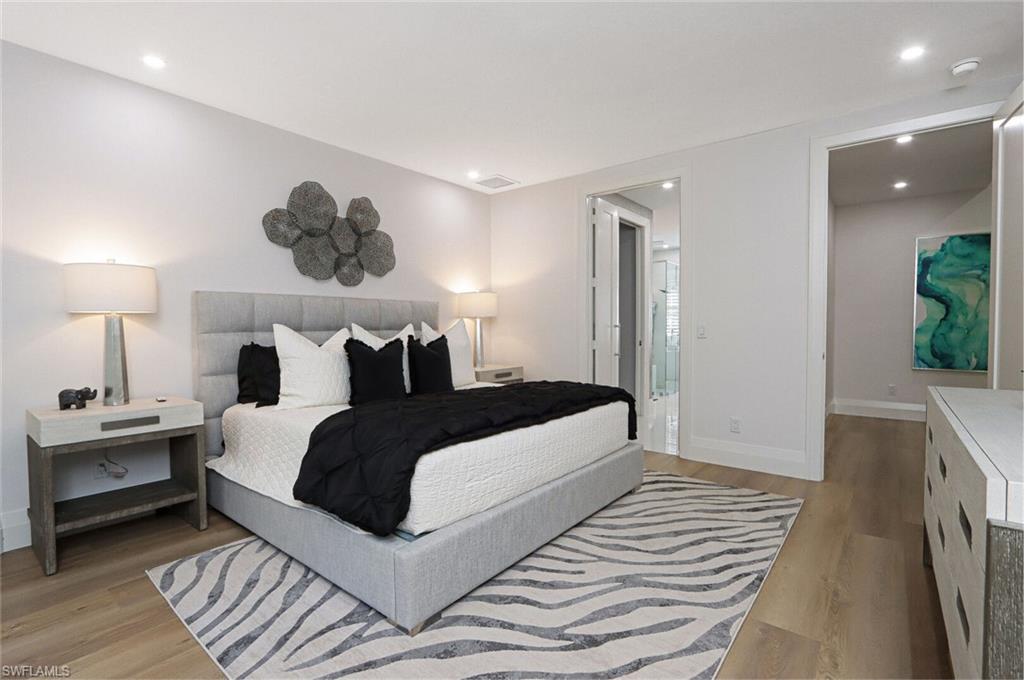 6665 Mill Run Road Naples, FL 34109 - Photo 15 of 30 a bedroom with a bed and a chandelier