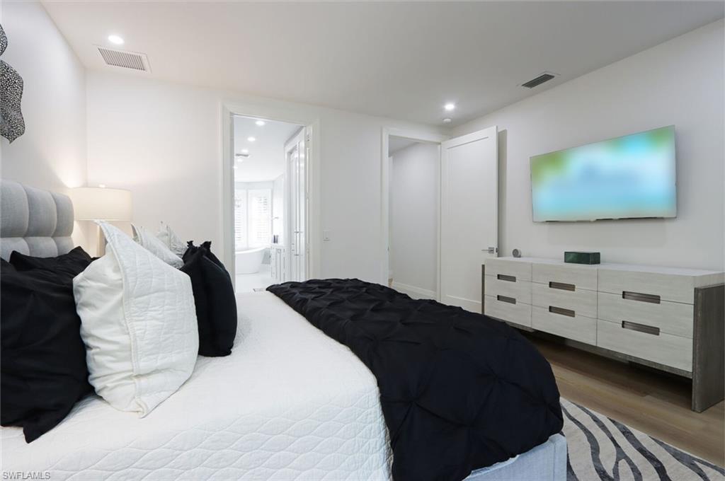 6665 Mill Run Road Naples, FL 34109 - Photo 16 of 30 a bedroom with a bed and a flat screen tv