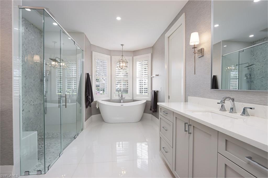 6665 Mill Run Road Naples, FL 34109 - Photo 17 of 30 a spacious bathroom with a double vanity sink large mirror and a bathtub