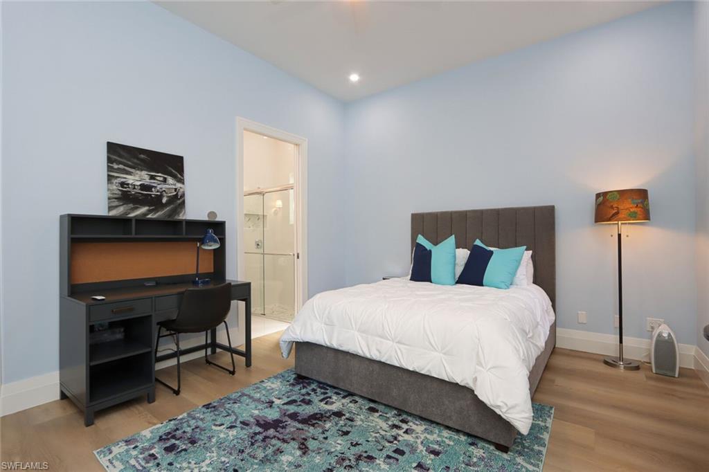 6665 Mill Run Road Naples, FL 34109 - Photo 18 of 30 a bedroom with a bed a desk and chair
