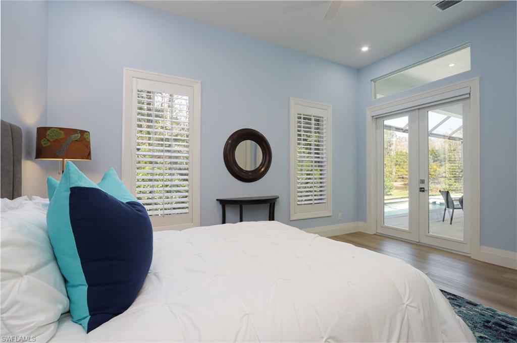 6665 Mill Run Road Naples, FL 34109 - Photo 19 of 30 a bedroom with a bed and a lamp