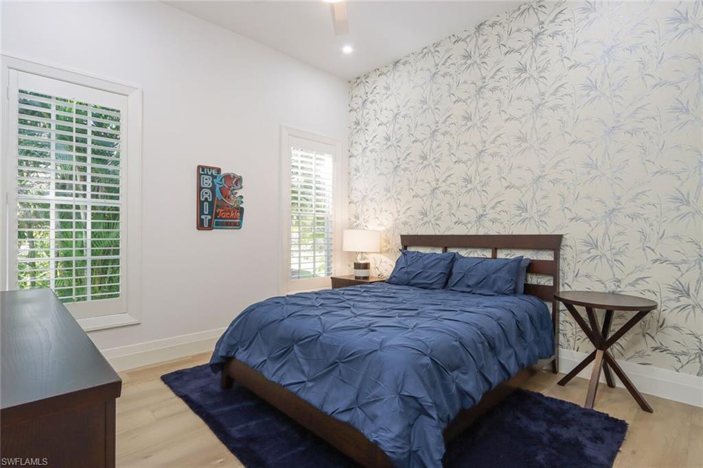 6665 Mill Run Road Naples, FL 34109 - Photo 28 of 30 a large bed sitting in a bedroom next to a window