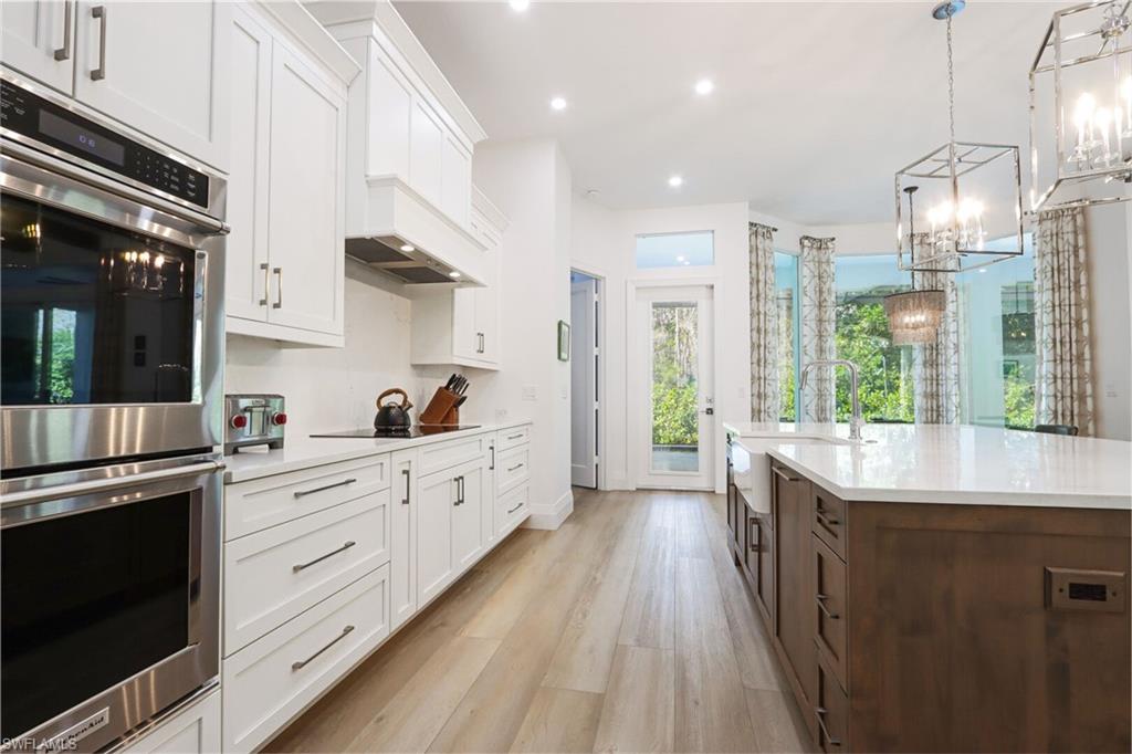 6665 Mill Run Road Naples, FL 34109 - Photo 7 of 30 a kitchen with stainless steel appliances granite countertop a sink a stove and a wooden floors