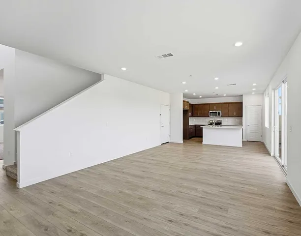 a view of an empty room with a kitchen