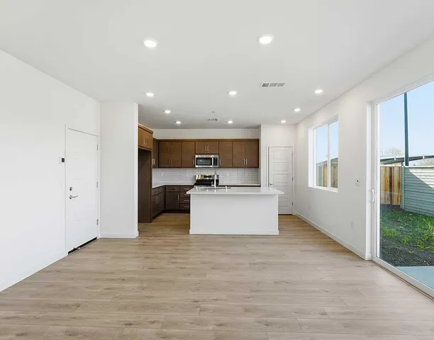 a view of kitchen with stainless steel appliances kitchen island a refrigerator sink and stove