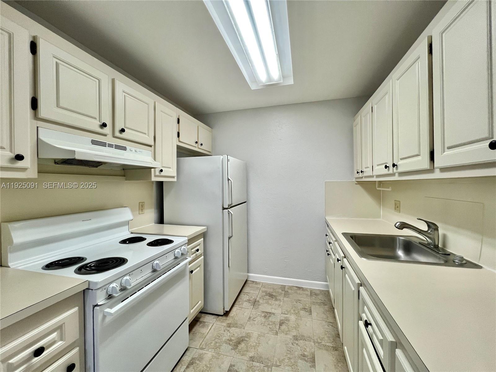 13550 Southwest 6th Court, Unit 109A Pembroke Pines, FL 33027 - Photo 6 of 11 a kitchen with a stove and a refrigerator
