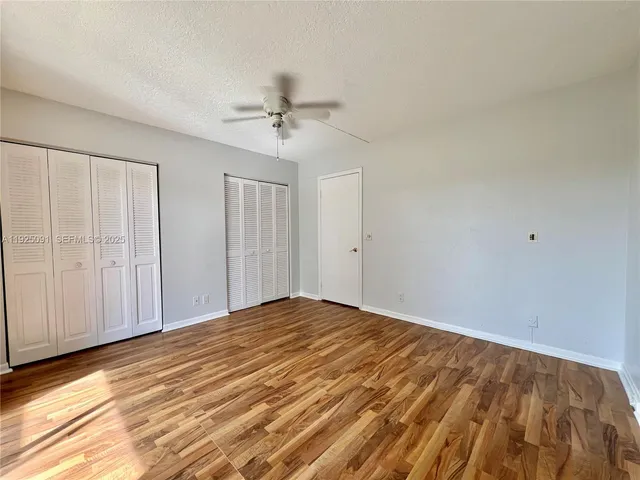 a view of empty room with window and ceiling fan