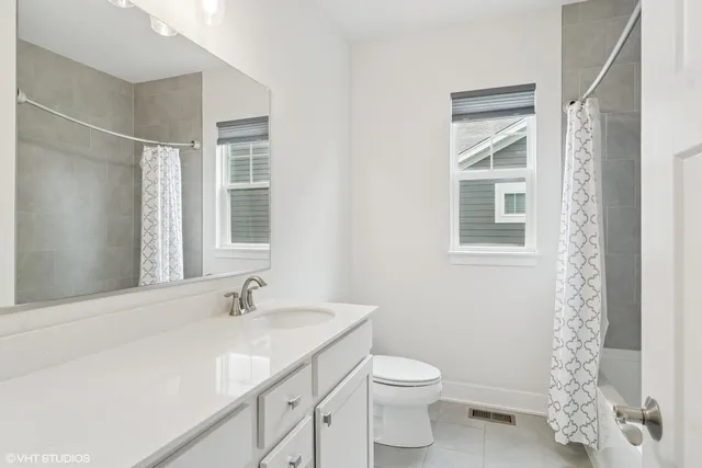 a bathroom with a granite countertop sink a toilet and a shower