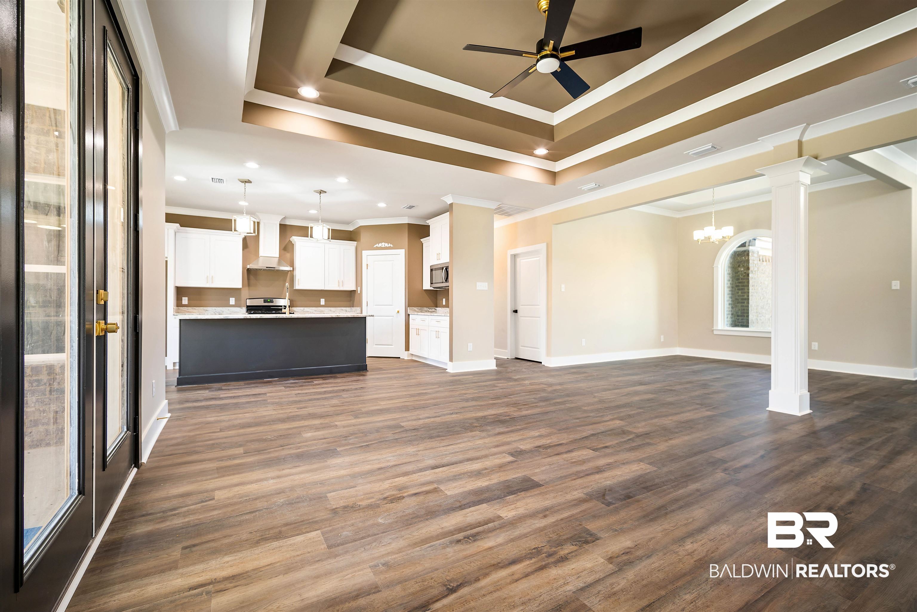 188 Hampton Ridge Mobile, AL 36608 - Photo 6 of 37 Family room with crown molding, a raised ceiling, ceiling fan with notable chandelier, and ornate column.
