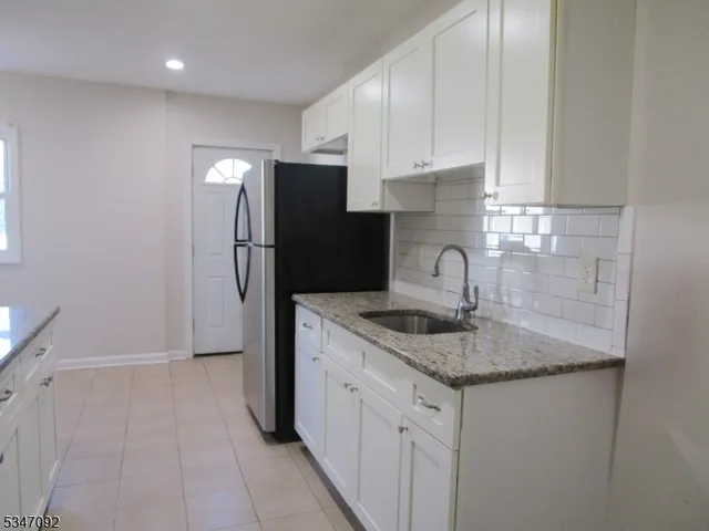 a kitchen with stainless steel appliances granite countertop a sink and a refrigerator