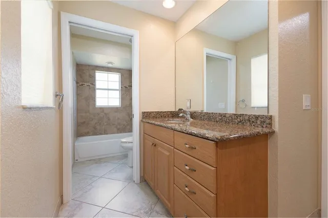 a bathroom with a granite countertop sink and a mirror