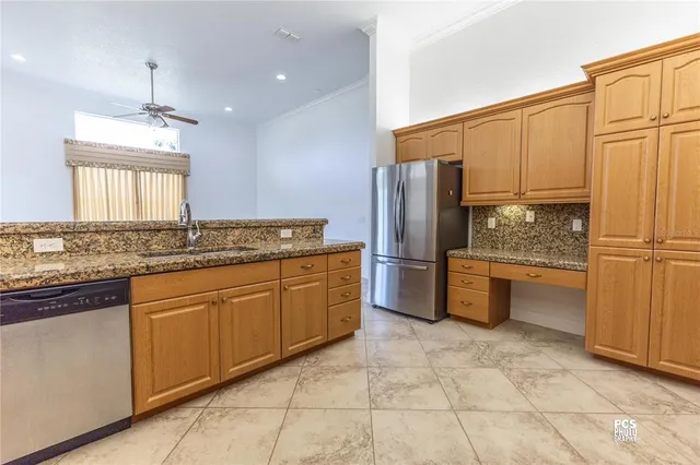 a kitchen with stainless steel appliances granite countertop a refrigerator and a sink