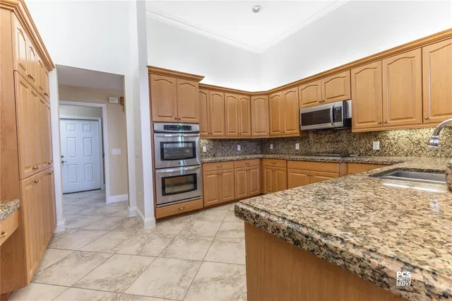 a kitchen with stainless steel appliances granite countertop a stove top oven a sink and dishwasher