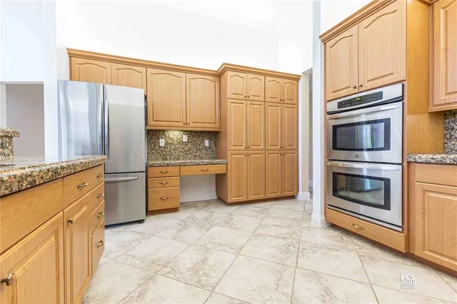 a kitchen with stainless steel appliances granite countertop a refrigerator and cabinets