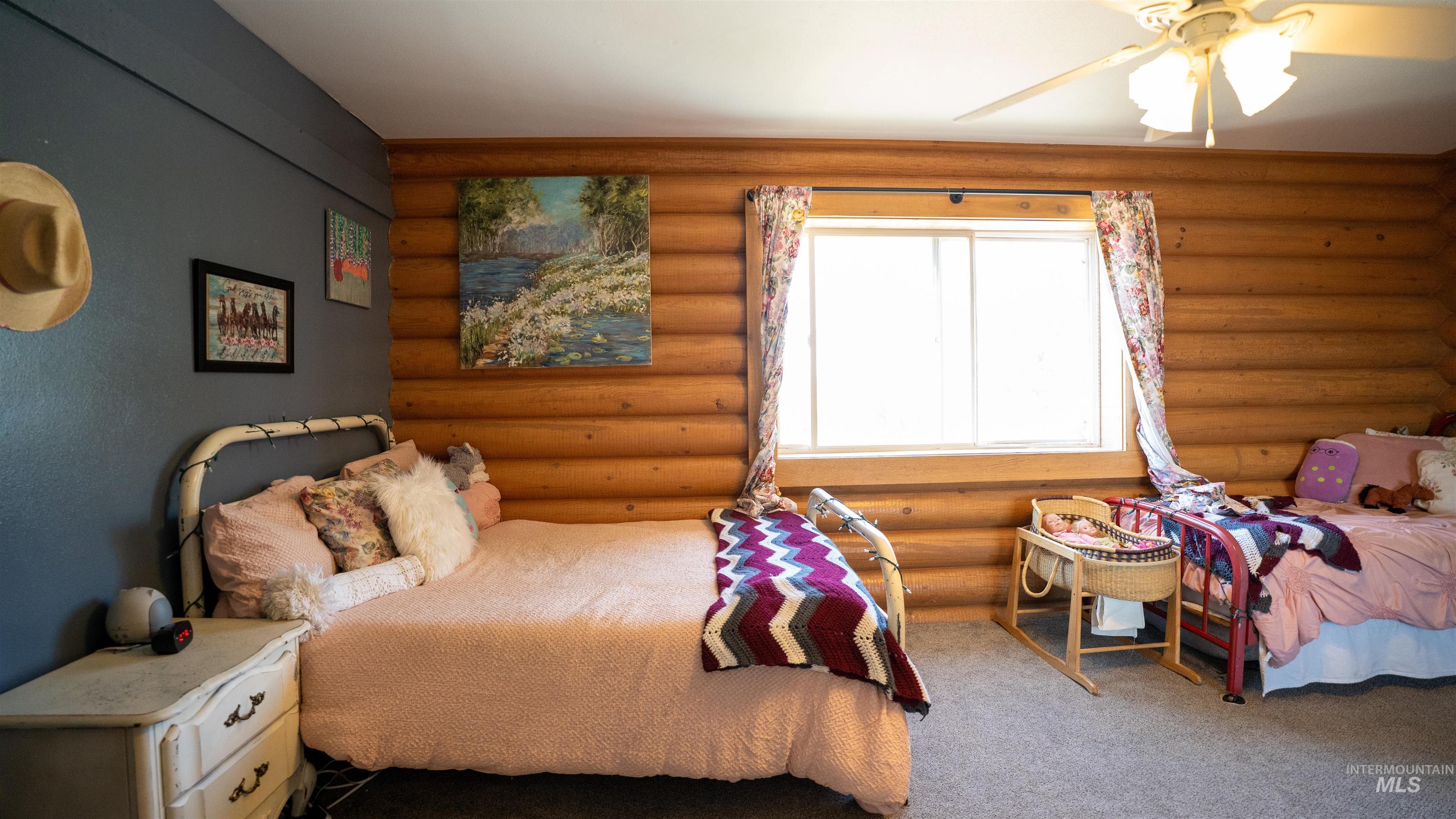 1321 Gold Hill Road Princeton, ID 83857 - Photo 11 of 29 Room featuring wood-finish bunk beds, log-style wall paneling, and a window with dark drapes