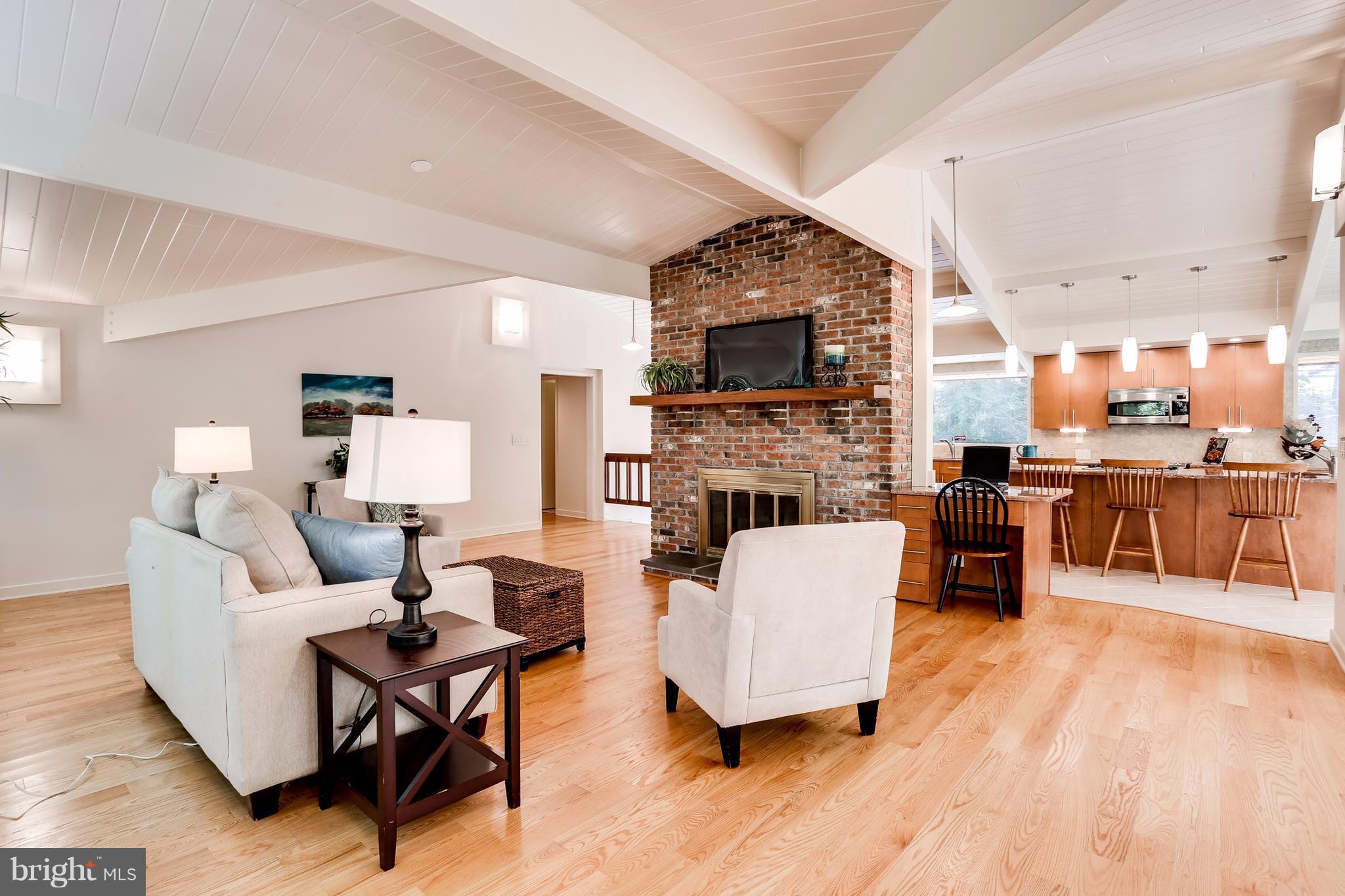 10900 Moxley Road Damascus, MD 20872 - Photo 2 of 30 a living room with furniture a fireplace a flat screen tv and kitchen view