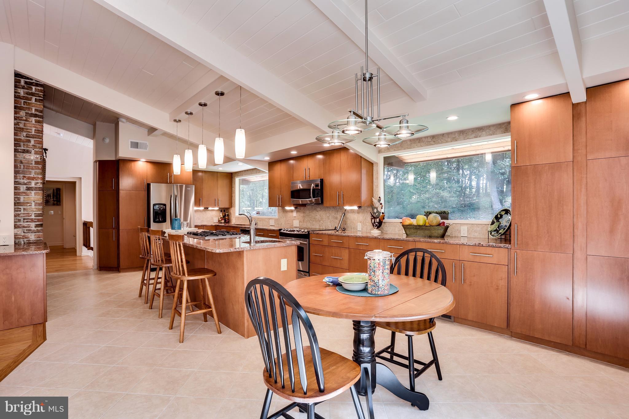 10900 Moxley Road Damascus, MD 20872 - Photo 13 of 30 a dining room with stainless steel appliances a table chairs and a kitchen view