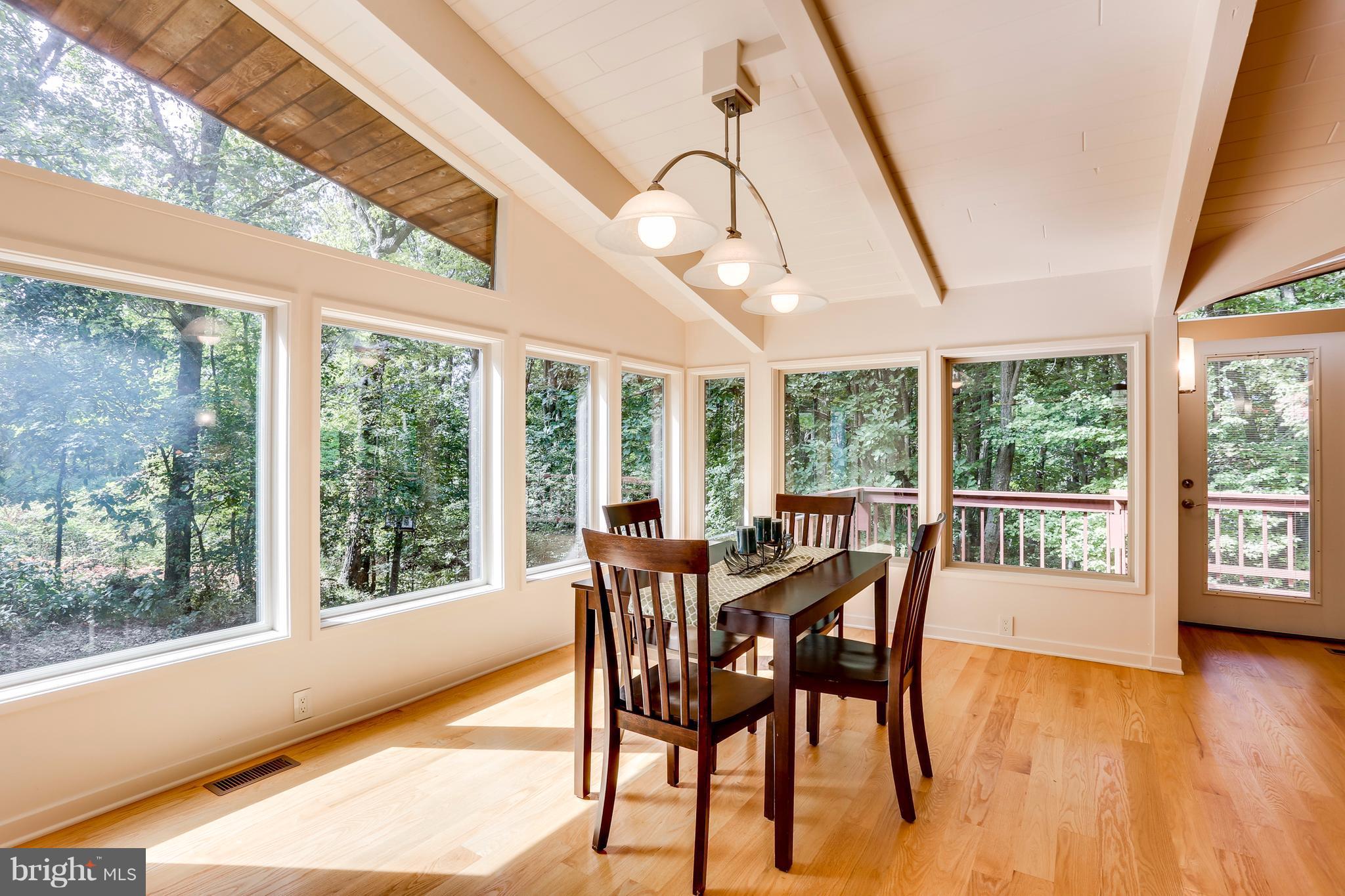 10900 Moxley Road Damascus, MD 20872 - Photo 8 of 30 a dining room with furniture large windows and wooden floor