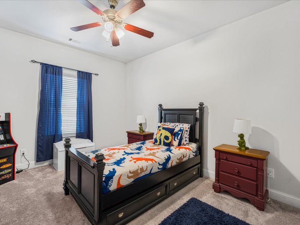 7675 Volion Drive Fairburn, GA 30213 - Photo 14 of 44 a bedroom with a bed and a chandelier