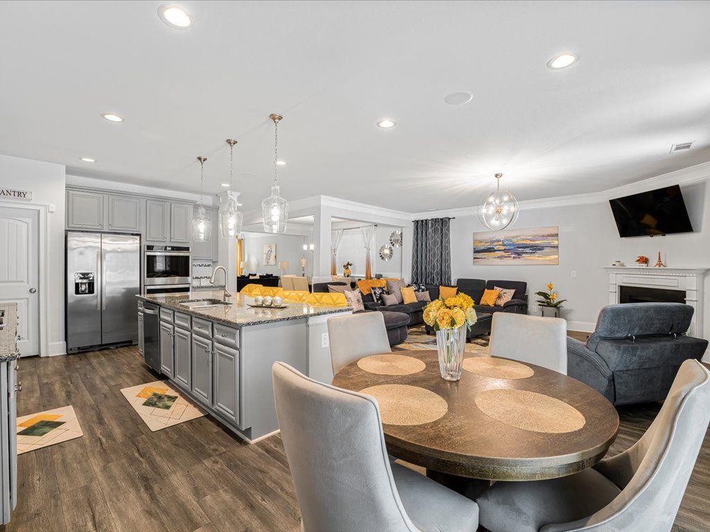 7675 Volion Drive Fairburn, GA 30213 - Photo 15 of 44 a kitchen with stainless steel appliances kitchen island granite countertop a sink a stove a dining table and chairs