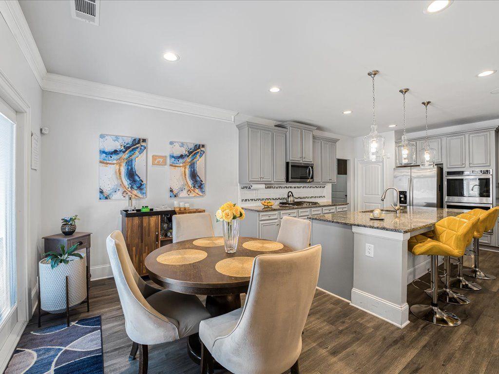 7675 Volion Drive Fairburn, GA 30213 - Photo 16 of 44 a kitchen with a dining table chairs stove a microwave and dining table